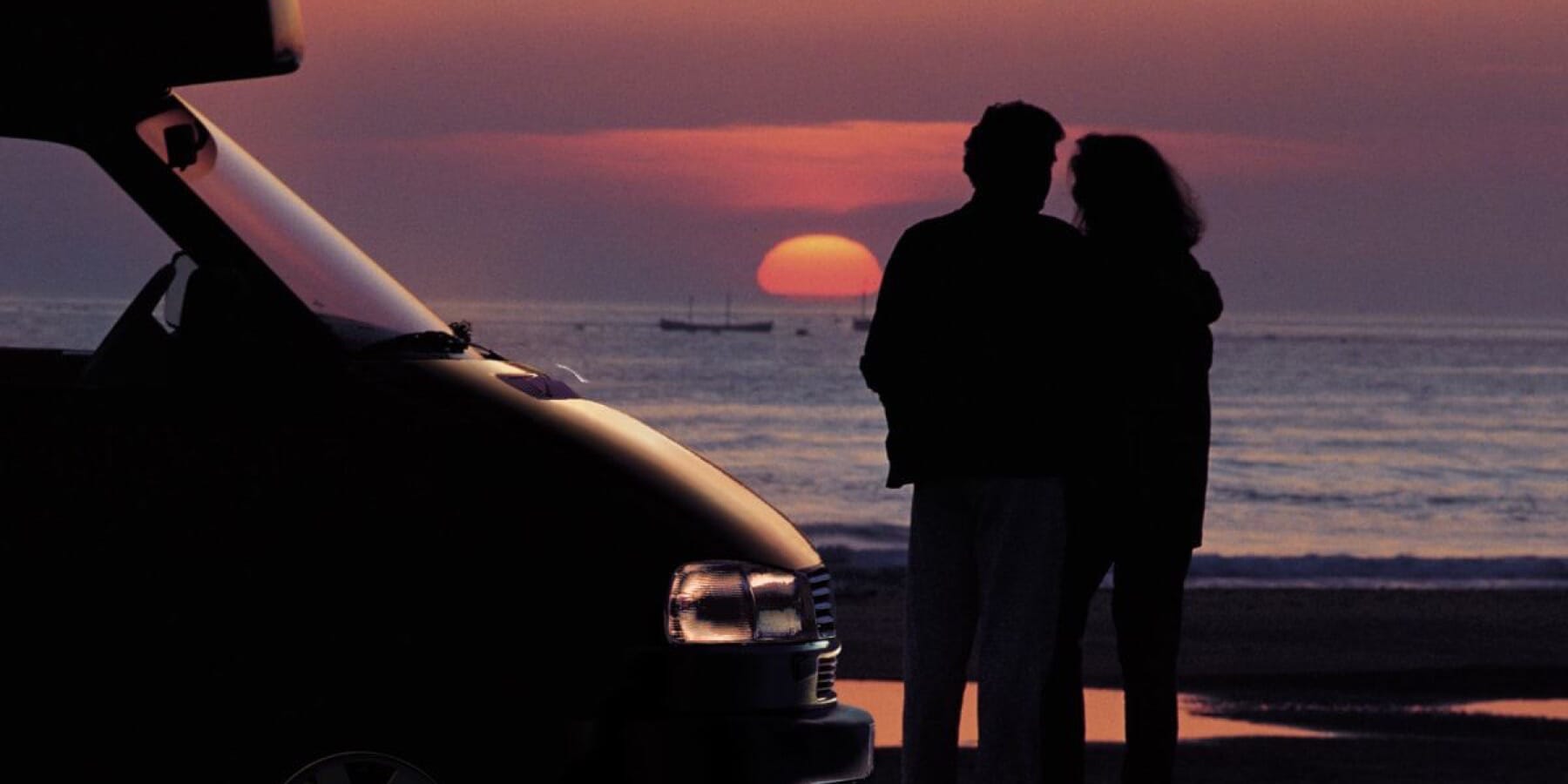 Volkswagen California mit Paar und Sonnenuntergang