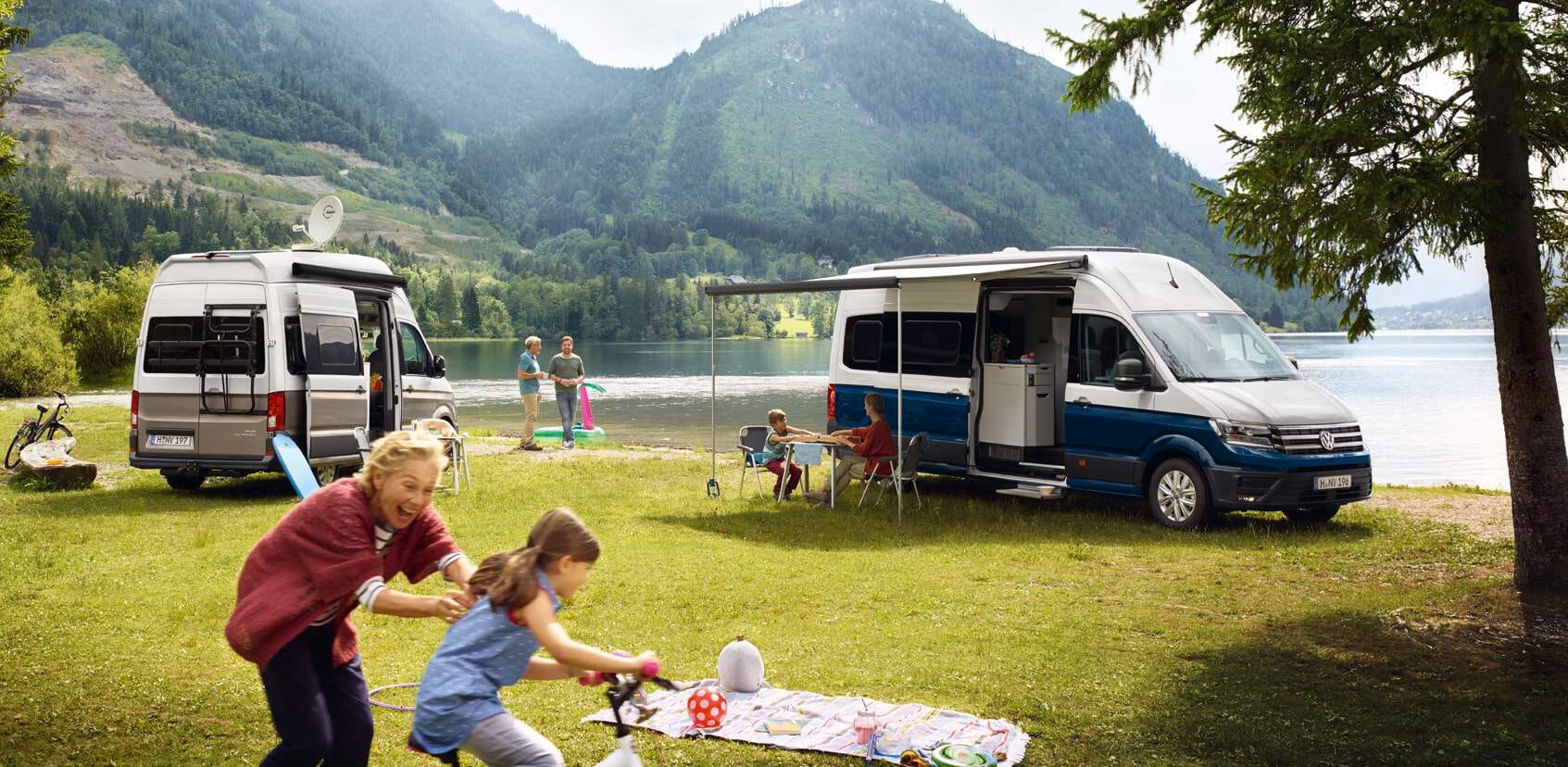 Volkswagen Grand California 600 und 680 zusammen neben ein See