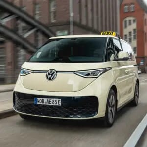 Der Volkswagen ID-Buzz-Taxi fährt über eine Brücke auf den Betracher zu.