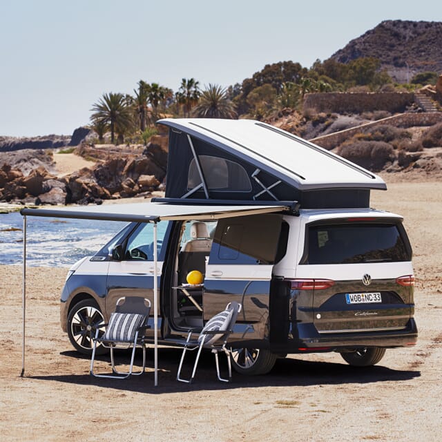 Volkswagen California 2024 Campervan mit ausgefahrenem Dach und Markise.