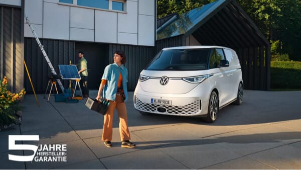 Weißer Volkswagen ID. Buzz Cargo vor einem modernen Gebäude, eine Handwerkerin trägt Werkzeug, während eine Person Solarpaneele installiert. Text: 5 Jahre Herstellergarantie.