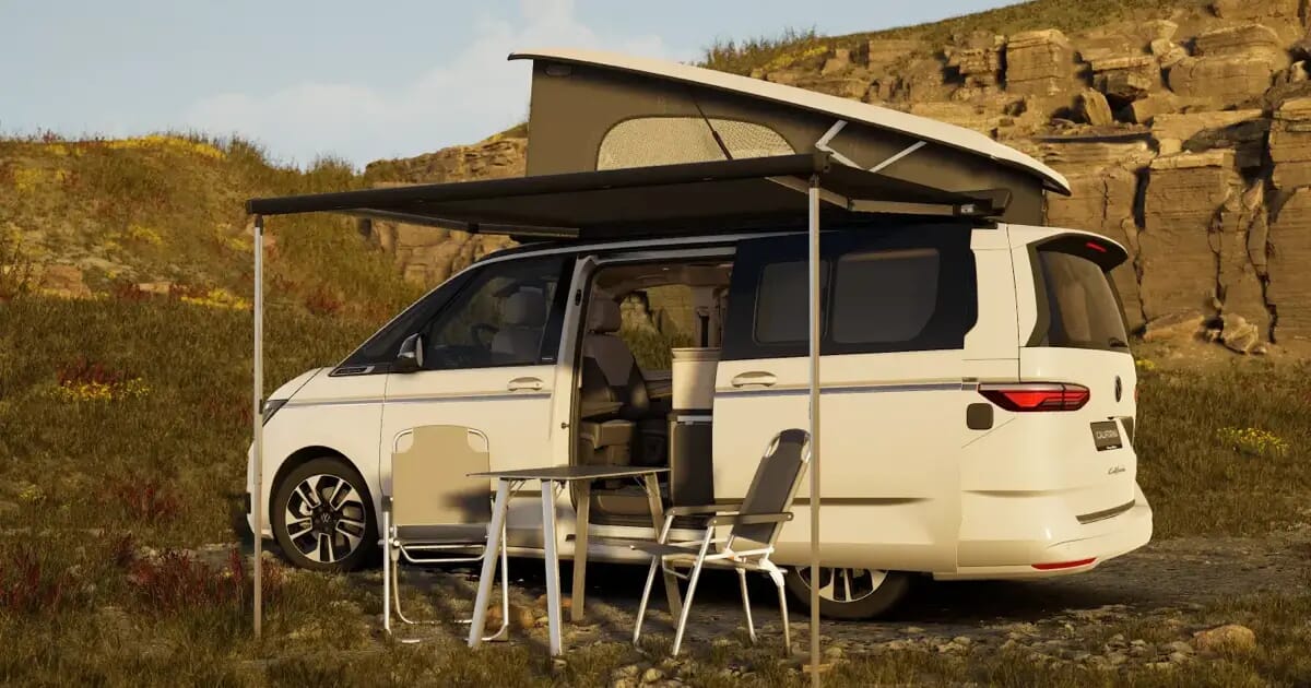 VW California Ocean Generation in Candy-Weiß mit geöffnetem Aufstelldach, Markise und Campingmöbeln in felsiger Landschaft.